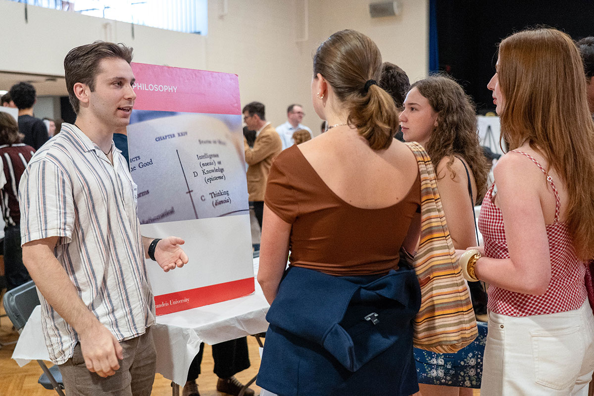 A group of students speak with an Undergraduate Departmental Representative at the Academic Fair.