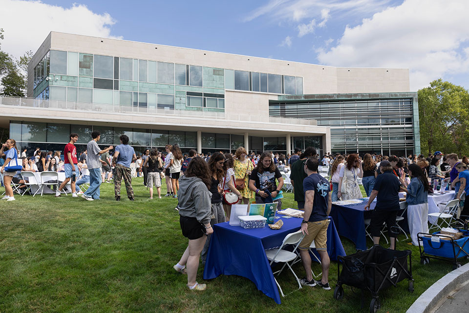 A large group of students gather outside on campus during the Hiatt Career Center Orientation.