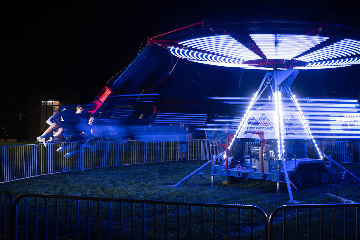 Two students ride a spinning carnival ride together.
