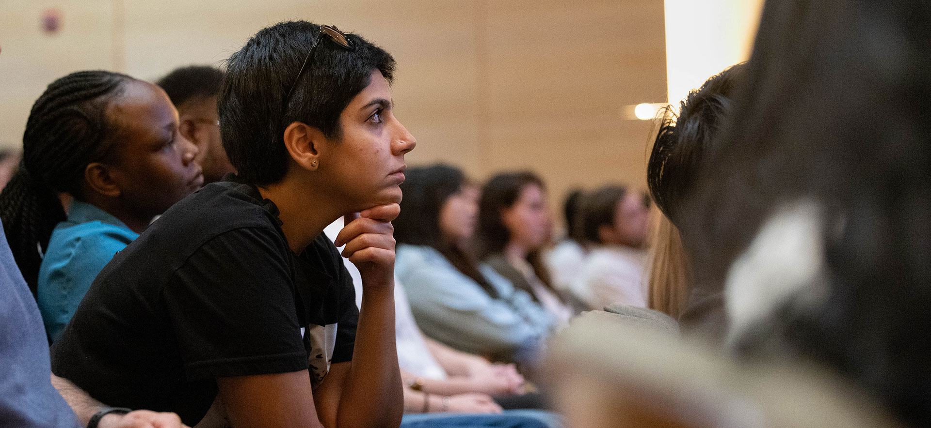 An audience of students sits in an auditorium.