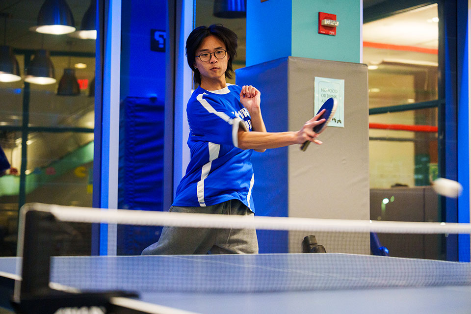 A student plays ping pong.