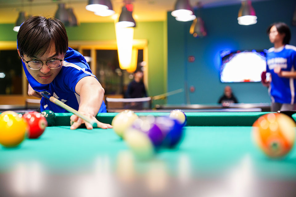 A student plays pool.