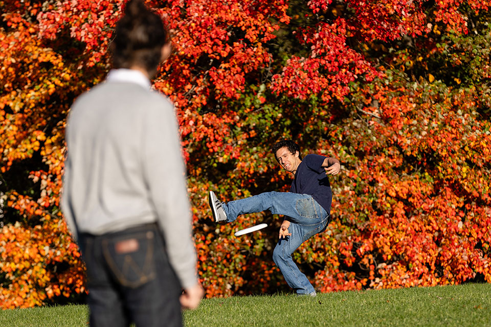 Students play frisbee outside on campus.