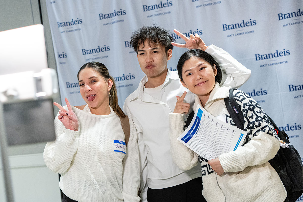 Three students pose to have their photo taken.
