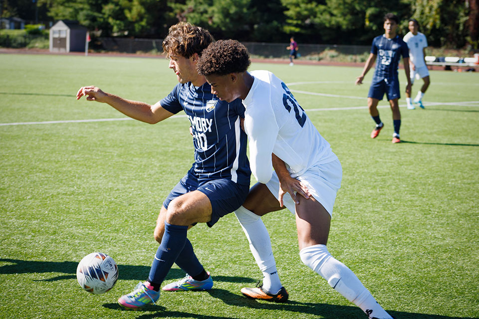 Two students play soccer.