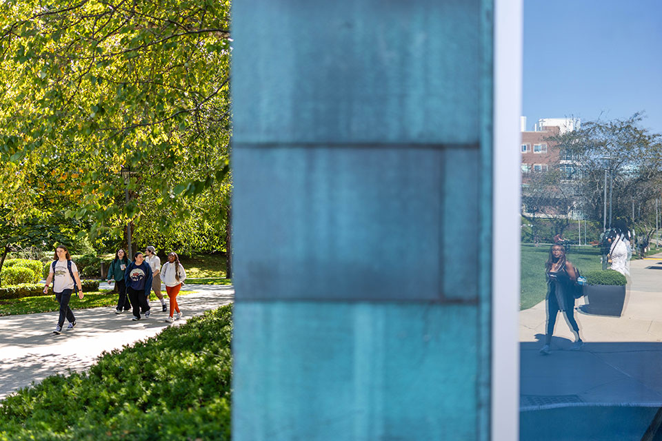 A group of students walk together on a path on campus.