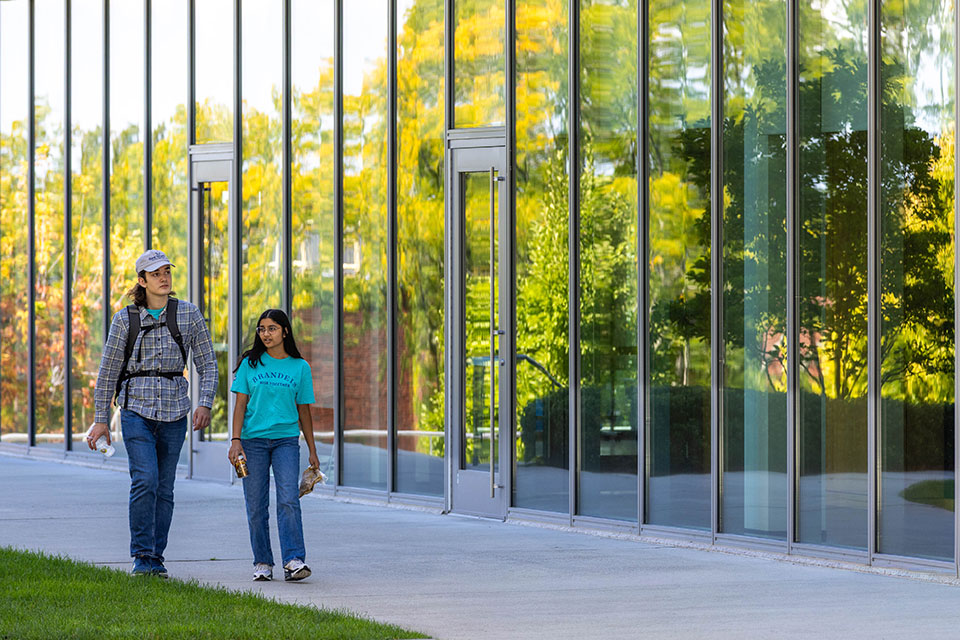 Two students walk together on campus.