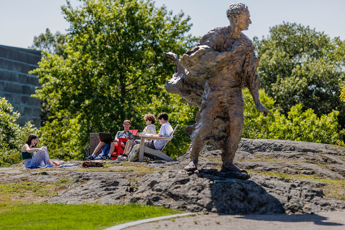Students sit in chairs next to the Louis Brandeis statue.