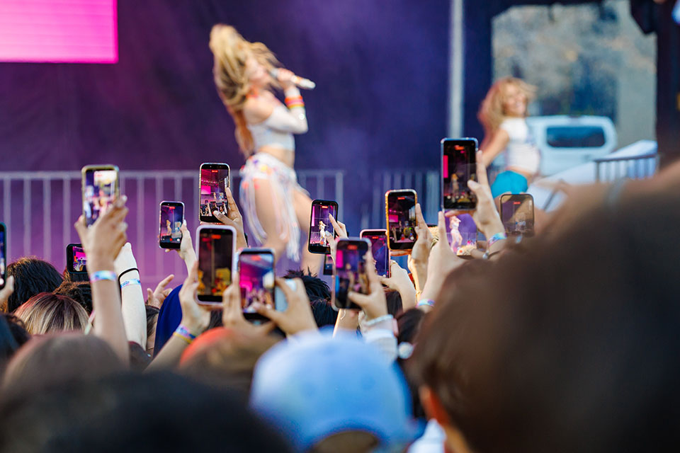 An audience of students film Zara Larsson on stage at Springfest.