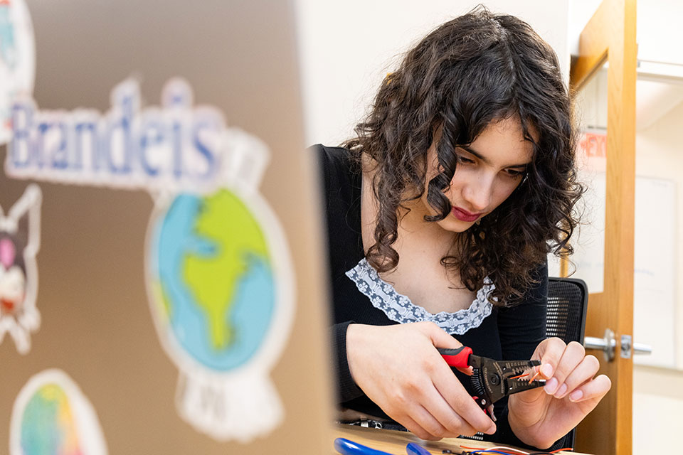 An engineering student working with a pair of wire cutters.