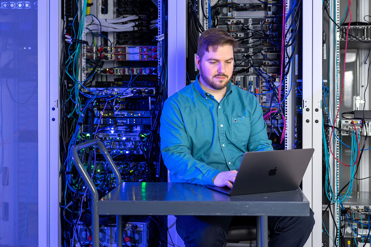 Professor Elijah Rivera working at a laptop.