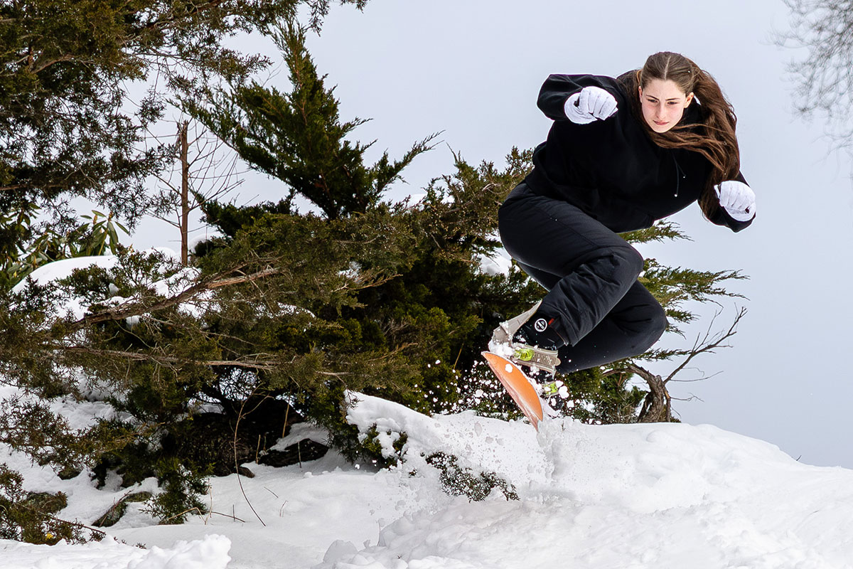 A student snowboarding on the Brandeis campus.