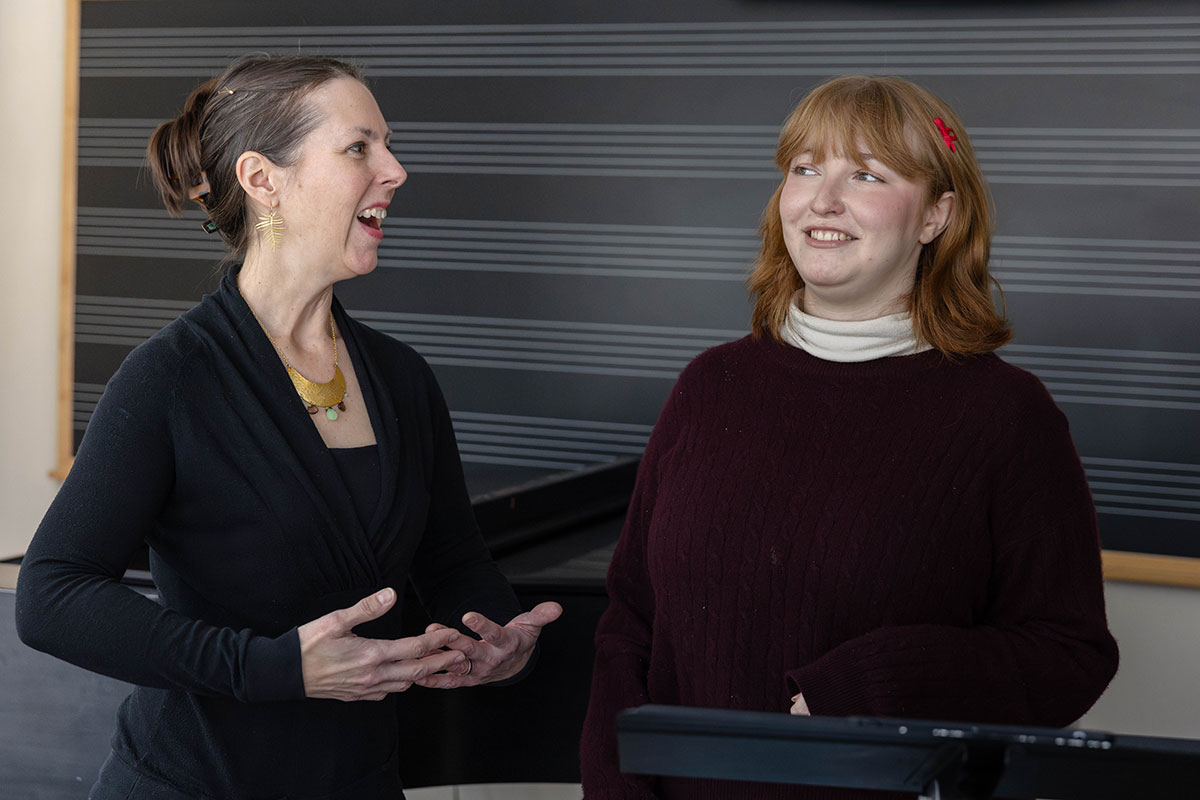 A voice instructor sings with a student.