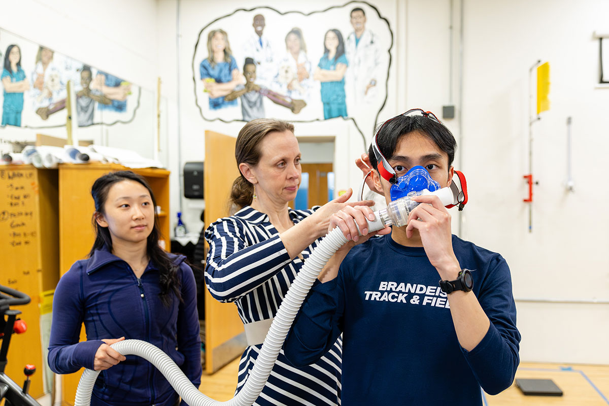A professor fits a student with a mask in the human performance lab.