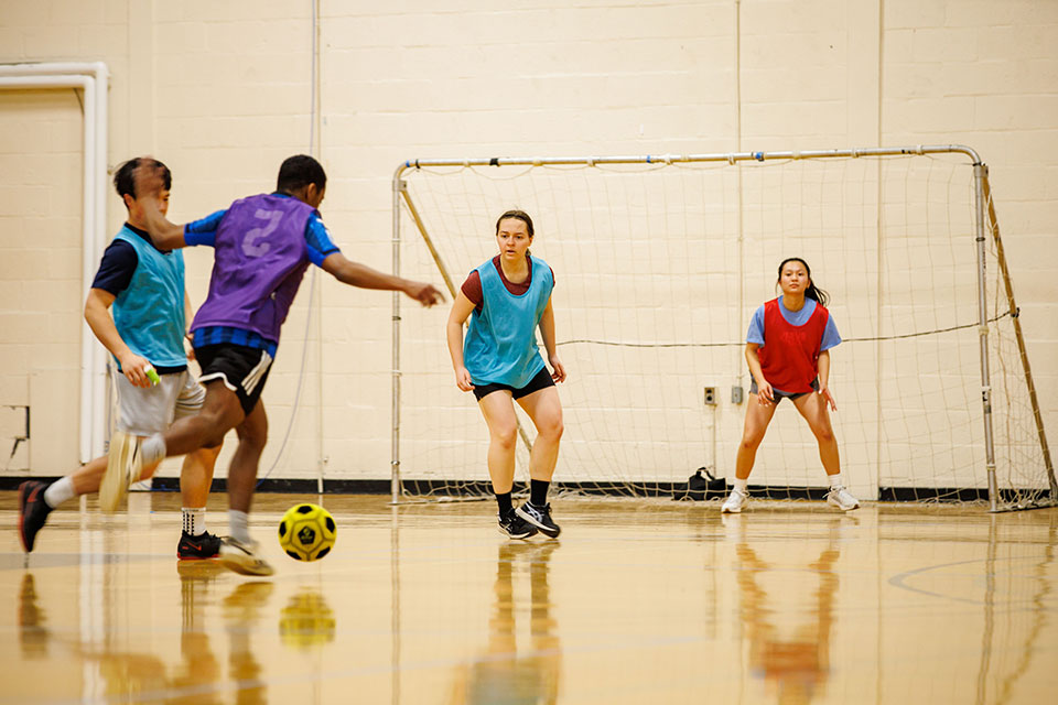 Students play indoors intramural soccer. 