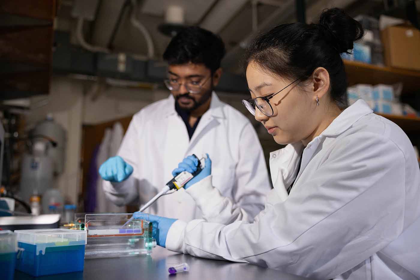 Two graduate students work in a lab