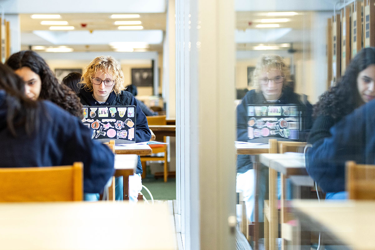 A student looks at their computer while studying. 