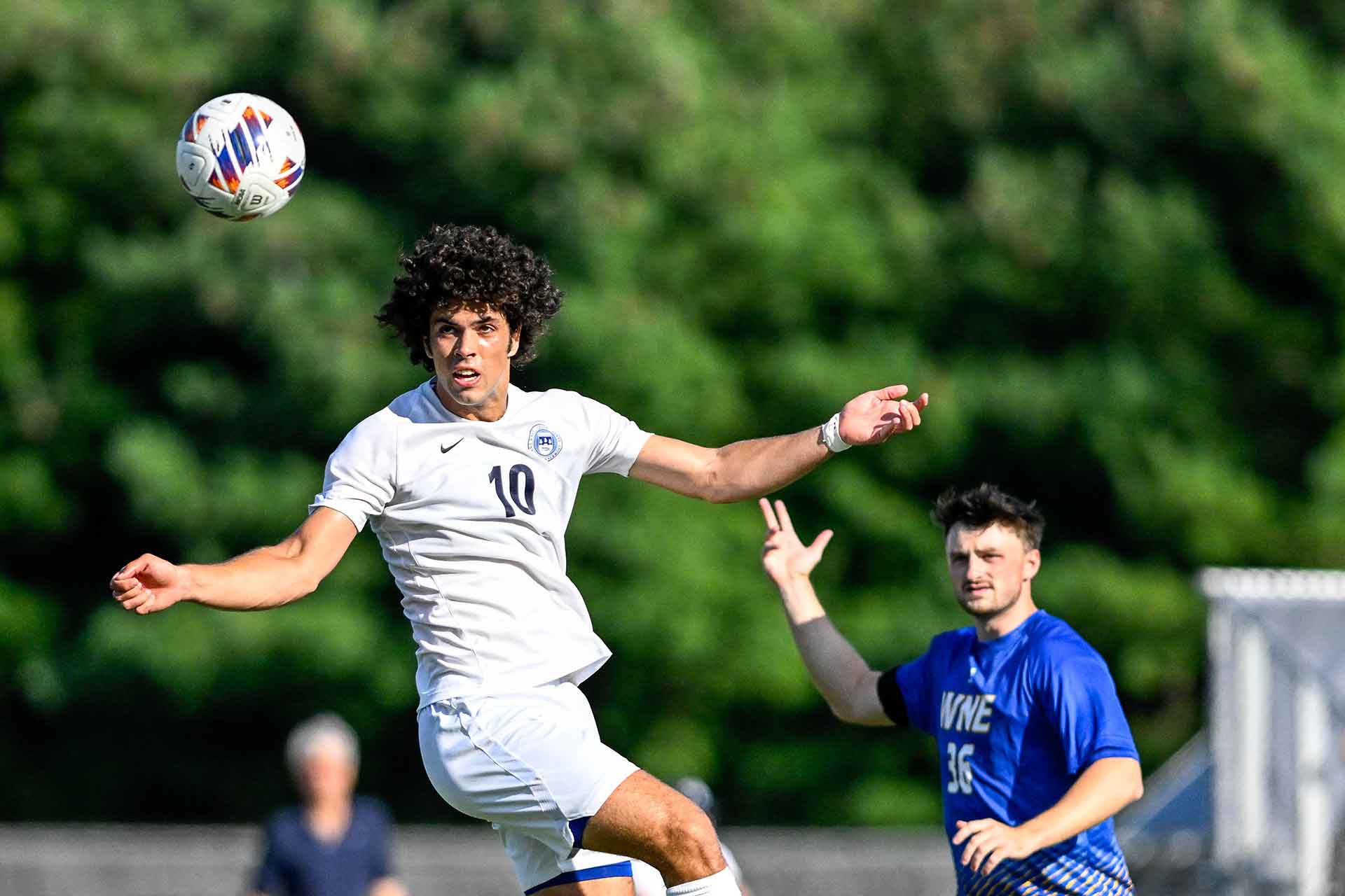 Brandeis and Western New England soccer players, a soccer ball appears suspended in air