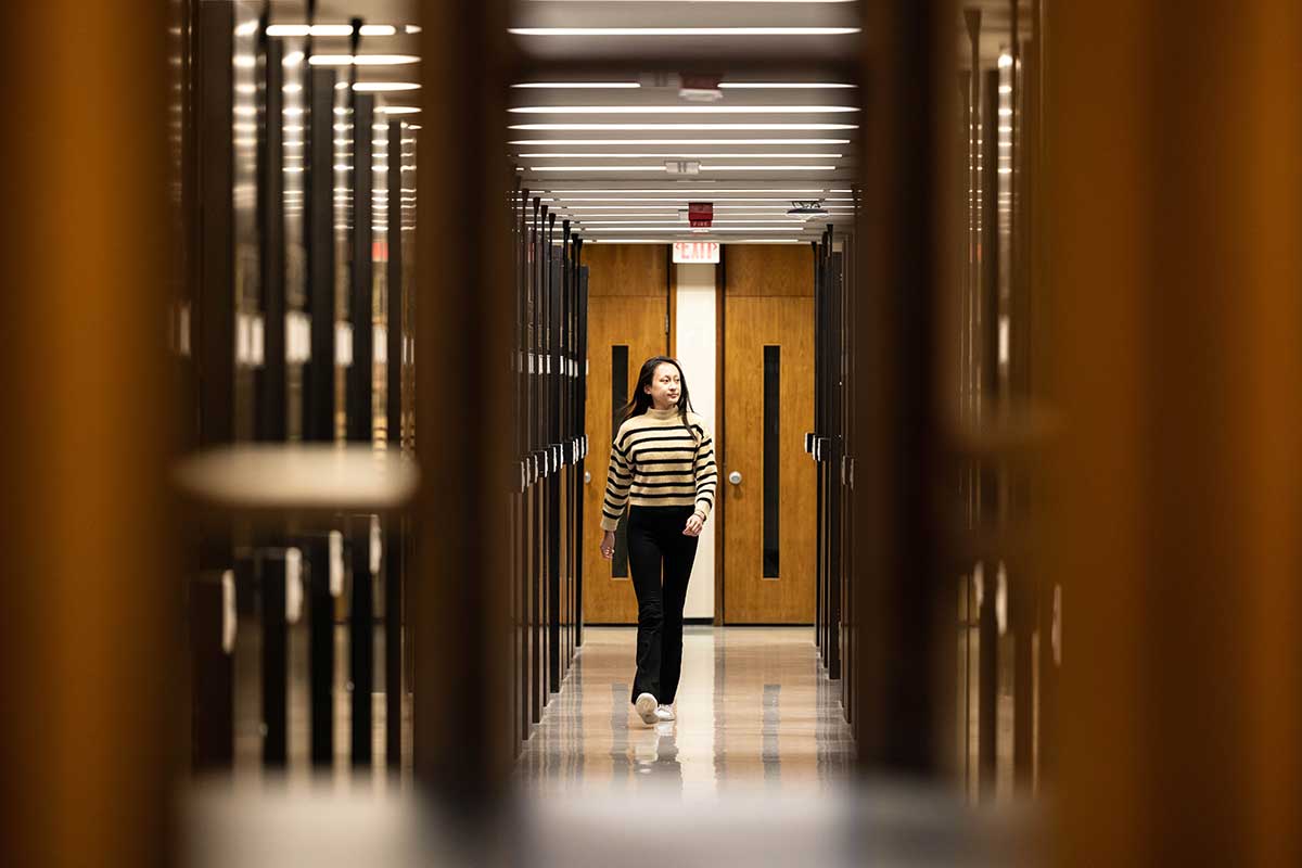 A person walks through the stacks in the Library.