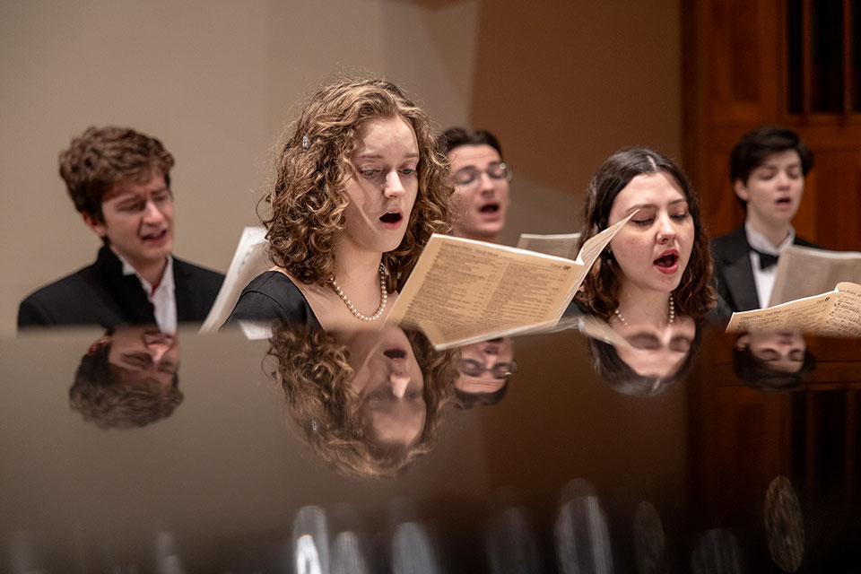 A group of students sing at a chorus practice