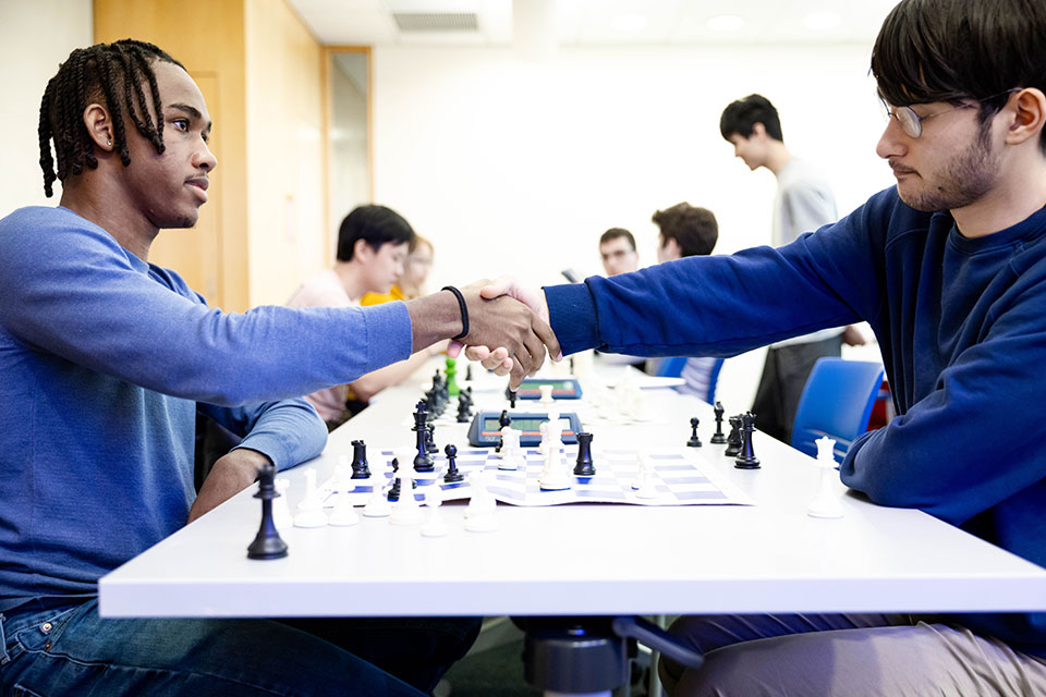 Two students shake hands at a chess tournament