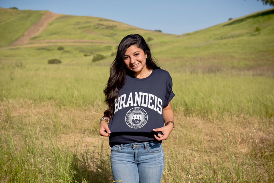 ysabel munoz standing in field, wearing brandeis t-shirt