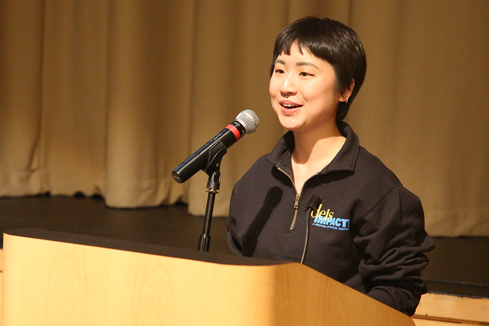 student in deis impact shirt speaking at podium