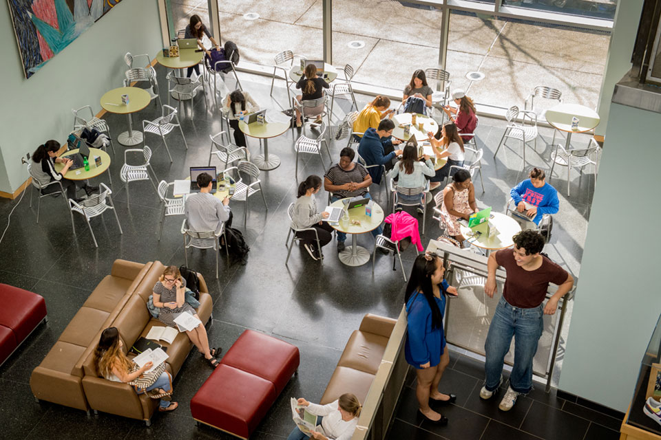 Overhead shot of students sitting in small groups at tables in Shapiro Campus Center