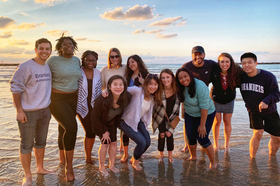 Volunteers huddled on a beach and smiling.