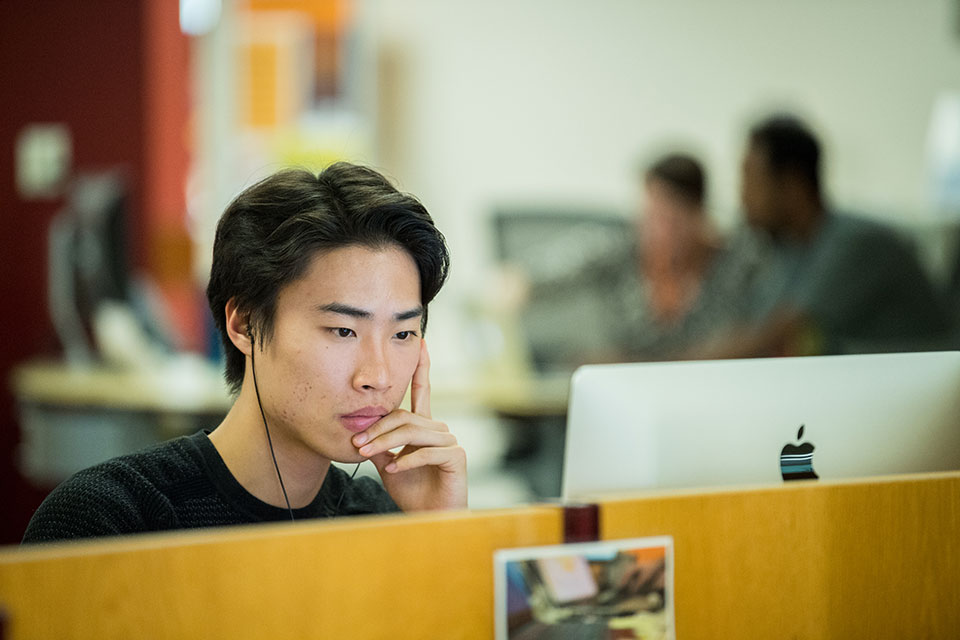 Student engaged in class in front of computer screen