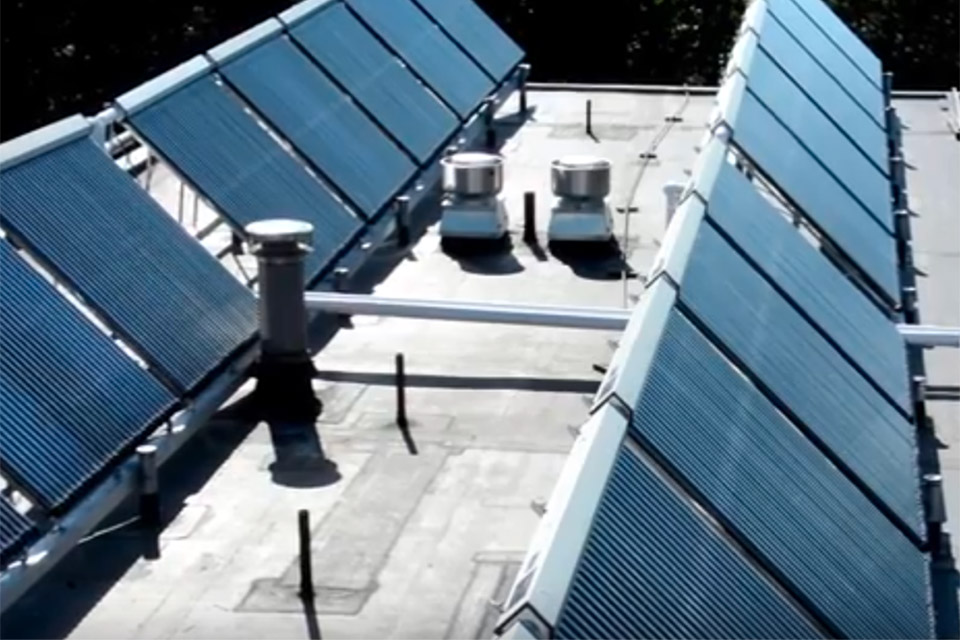 two rows of blue solar thermal panels on a rooftop