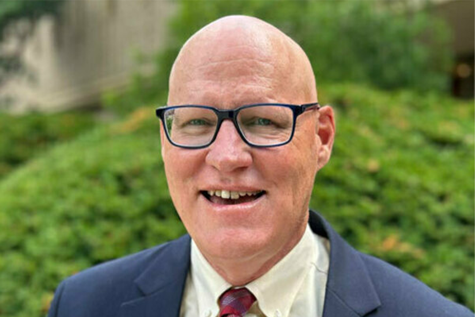 photo of Thomas Burman in front of a background of green foliage
