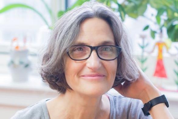 Photo of Tamar Hess in front of a background with windows