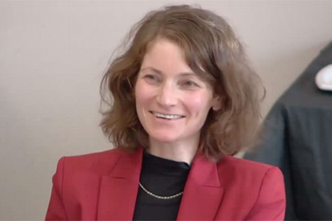 An image of Hadar Feldman Samet in a red blazer smiling at the Jewish Studies Colloquium.