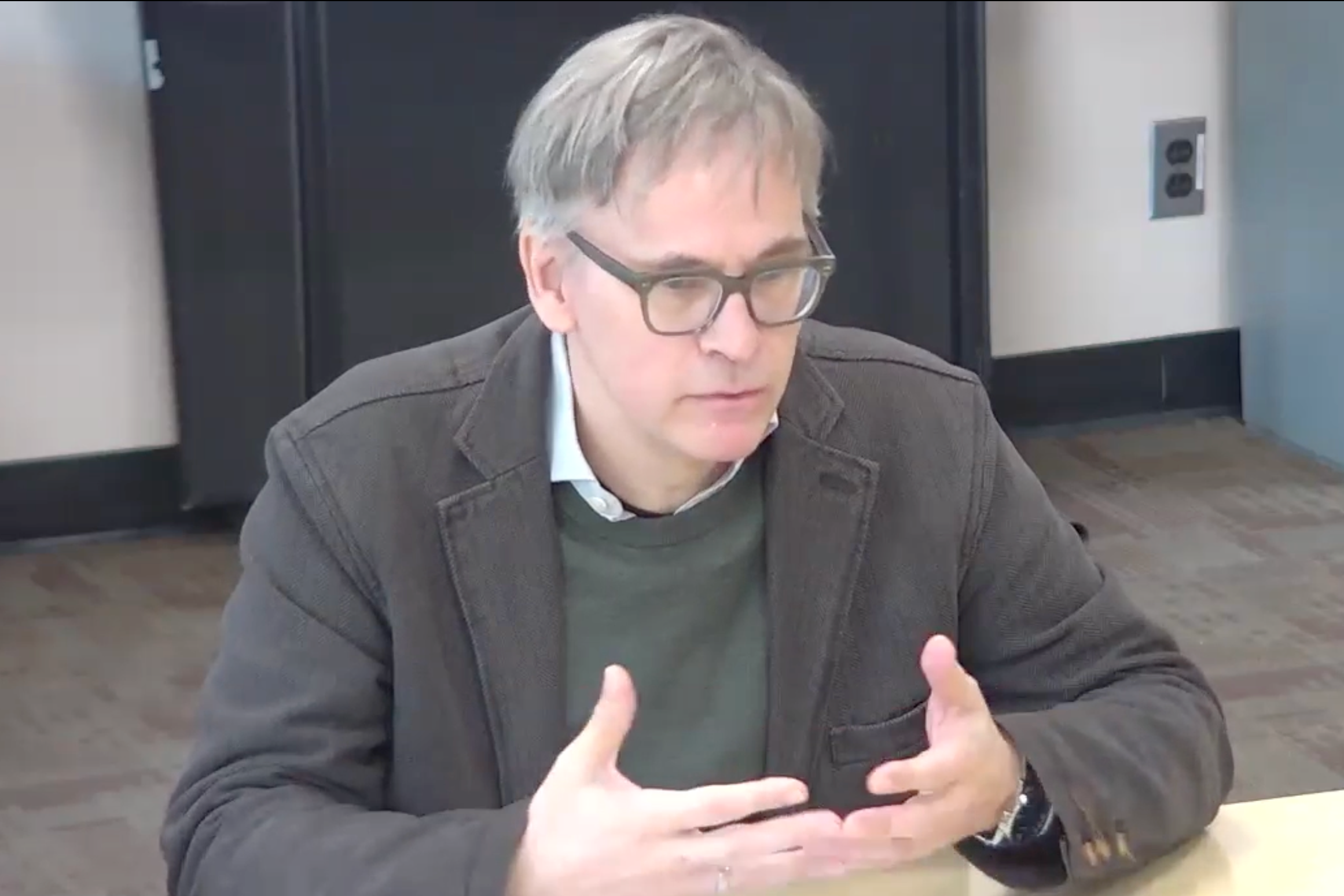 An image of Sven-Erik Rose participating in an author conversation series event on Rose's book