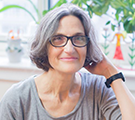 The portrait photo of Tamar Hess wearing a grey T-shirt and glasses