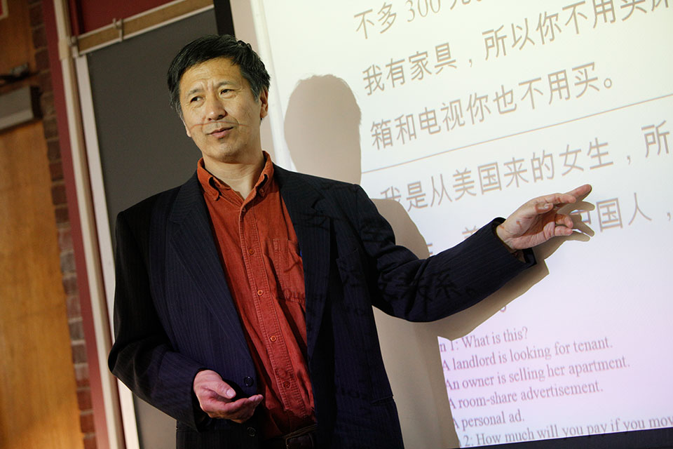 Yu Feng standing in front of a projector with Chinese text