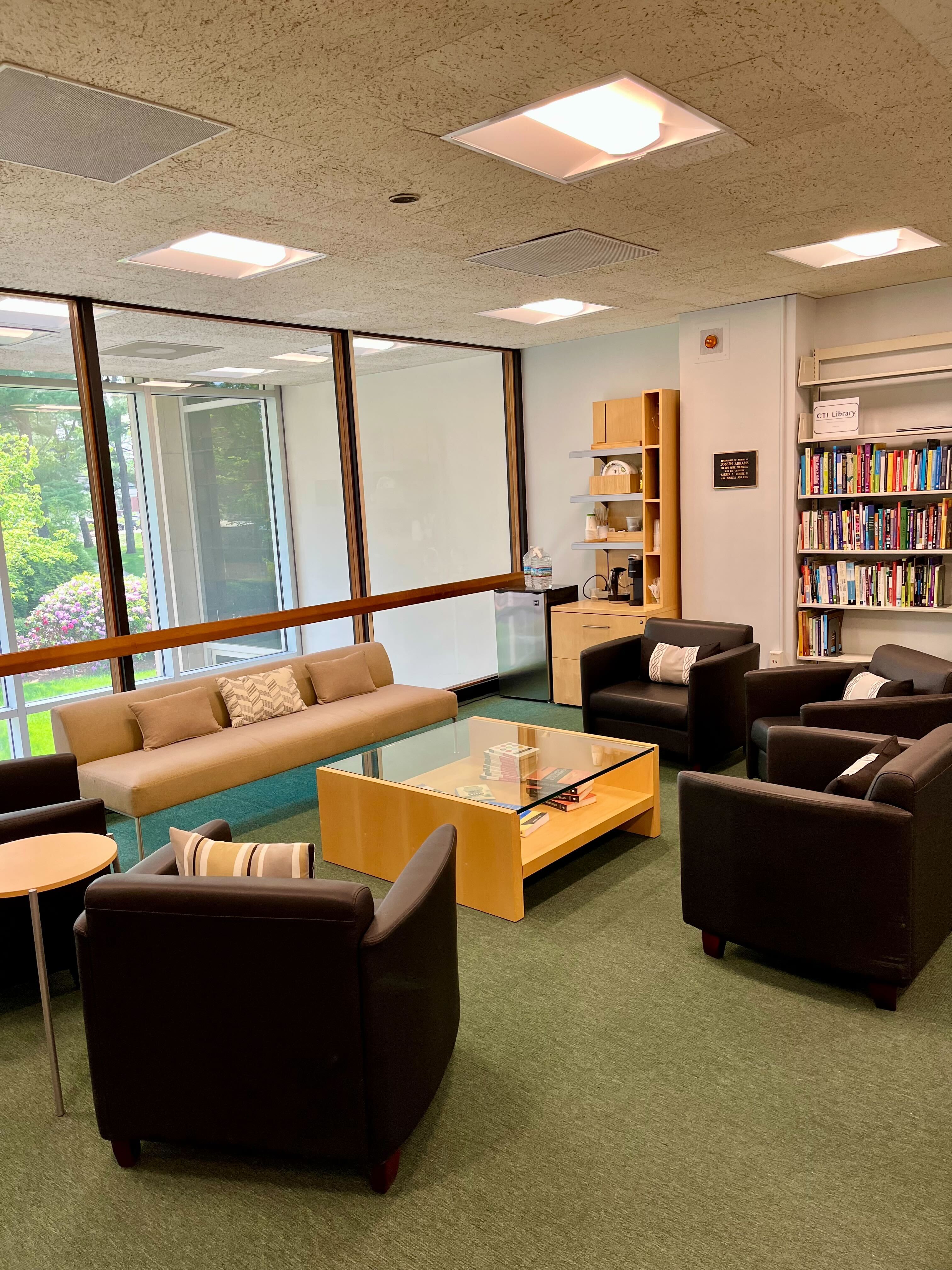 Chairs, sofa, bookshelves, and coffee station inside the Center for Teaching and Learning on the Goldfarb mezzanine
