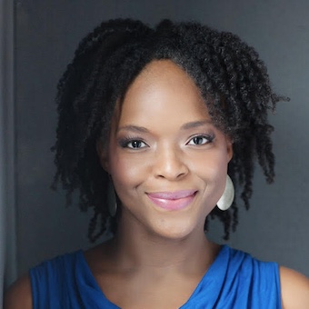 black woman in a blue sleeveless shirt, smiling