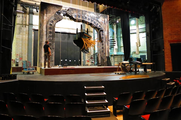 Inside a theater, hanging a piano prop