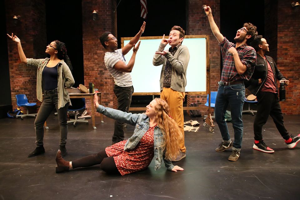 A group of theater students stand on stage.