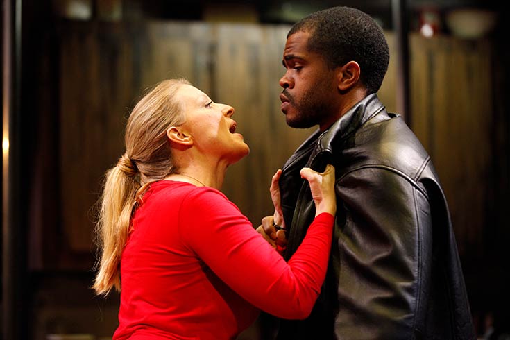 Female actor holding the collar of a male actor's leather jacket in Escape from Happiness