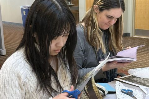 Two students cut images from magazines