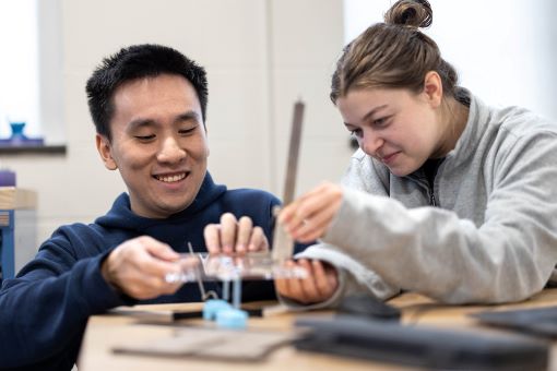 two students examine a piece of equipment