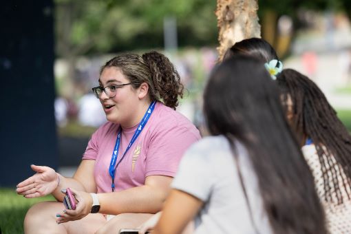 an orientation guide speaks excitedly with a group of new students