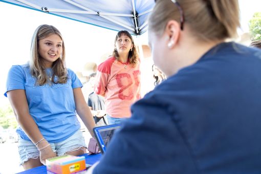 an orientation guide speaks excitedly with a group of new students