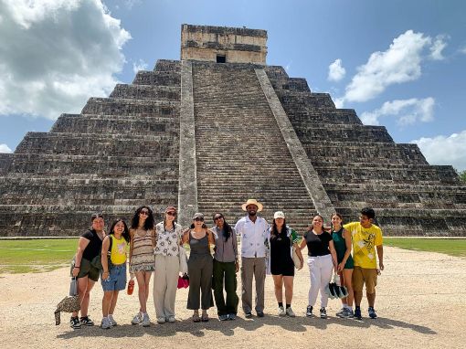 a group of students standing in front of a temple in Mexico
