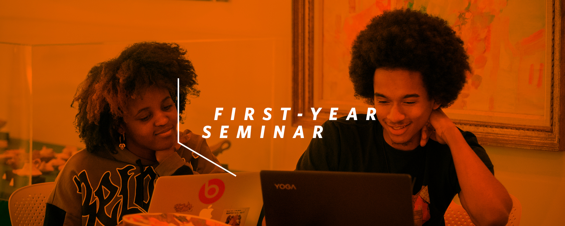 two students on their laptops, overlaid by words first-year seminar.