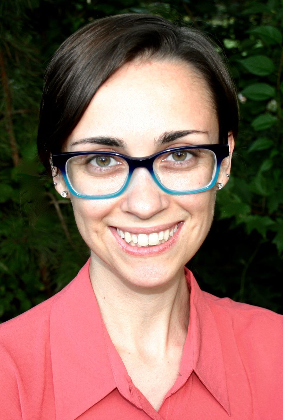 Yanna has short brown hair and wears glasses