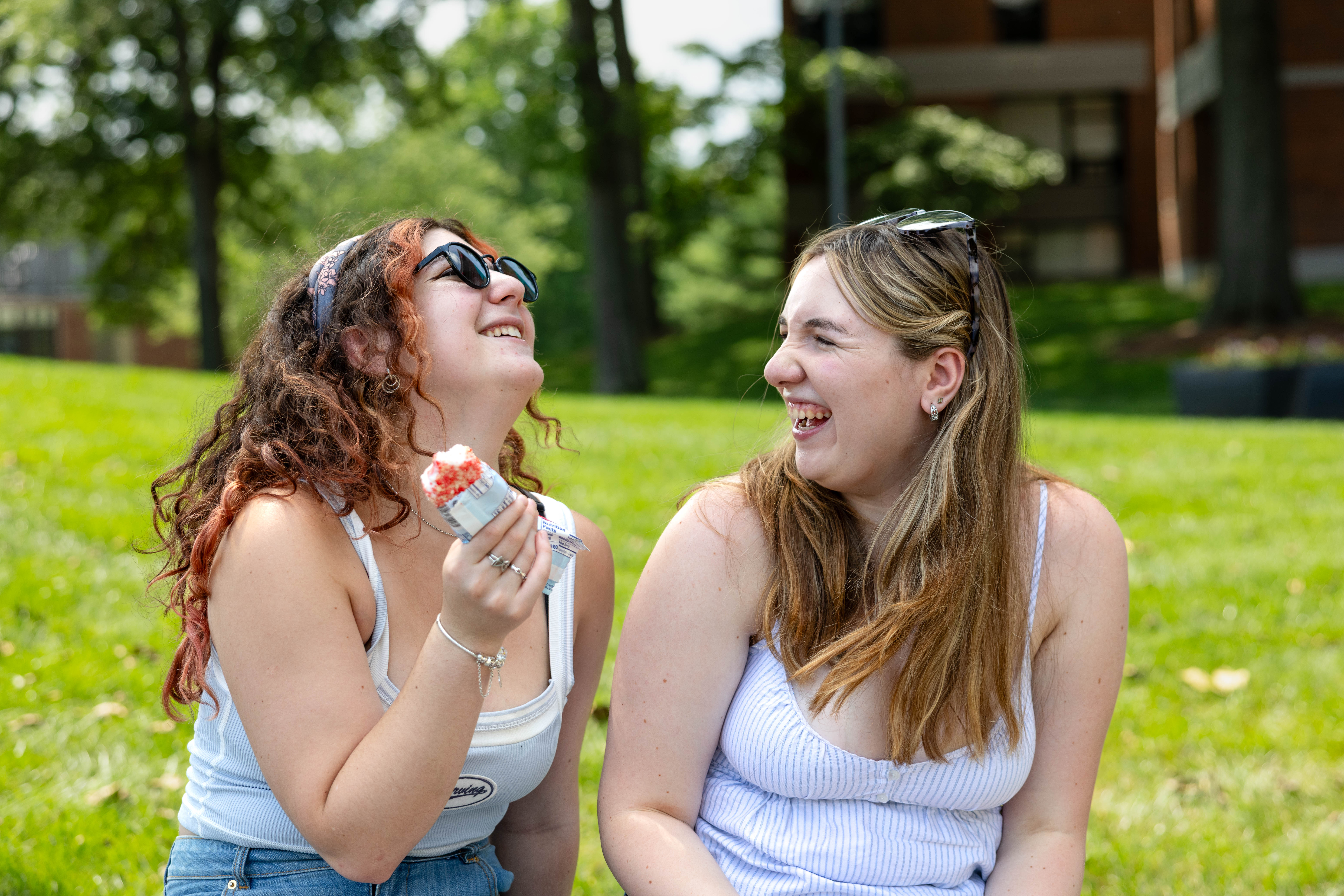 two students sitting outside laughing